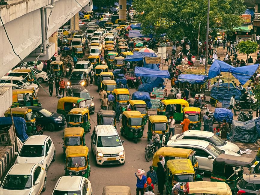 Delhi’s Barapullah Phase-III Corridor Faces Severe Traffic Congestion Days After Opening Dynamic aerial view of a busy New Delhi street with auto-rickshaws and pedestrians in a lively market.