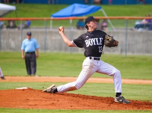 Dynamic shot of a baseball pitcher mid-throw during a daytime game.
