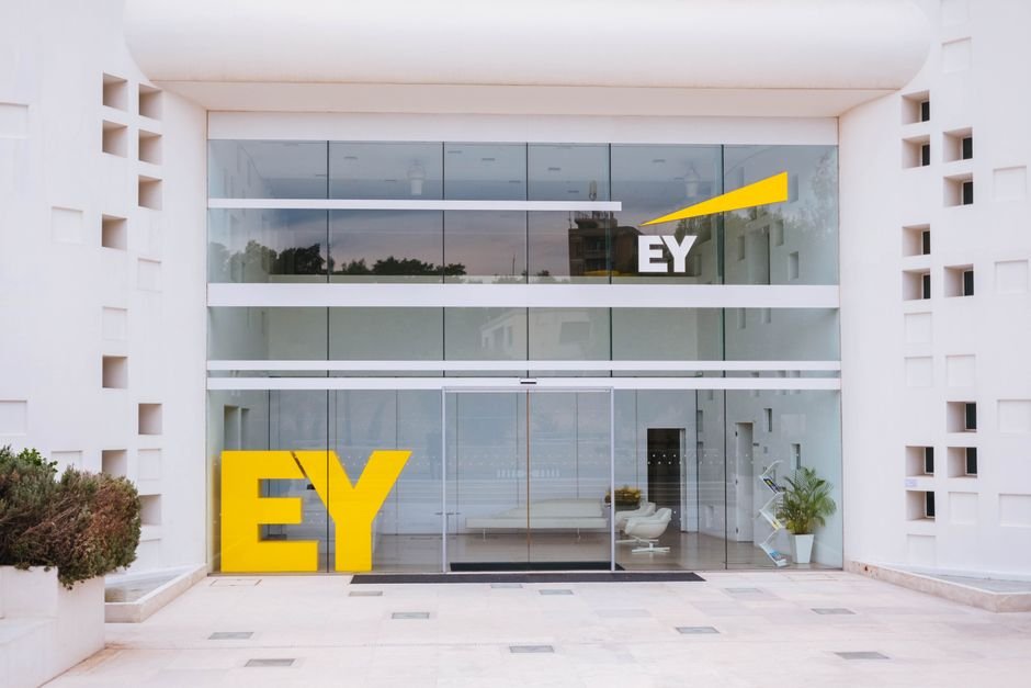 Ernst & Young Emphasizes Robust ESG Reporting and Risk Management Frameworks Exterior view of a corporate building entrance with EY logo and minimalist design.