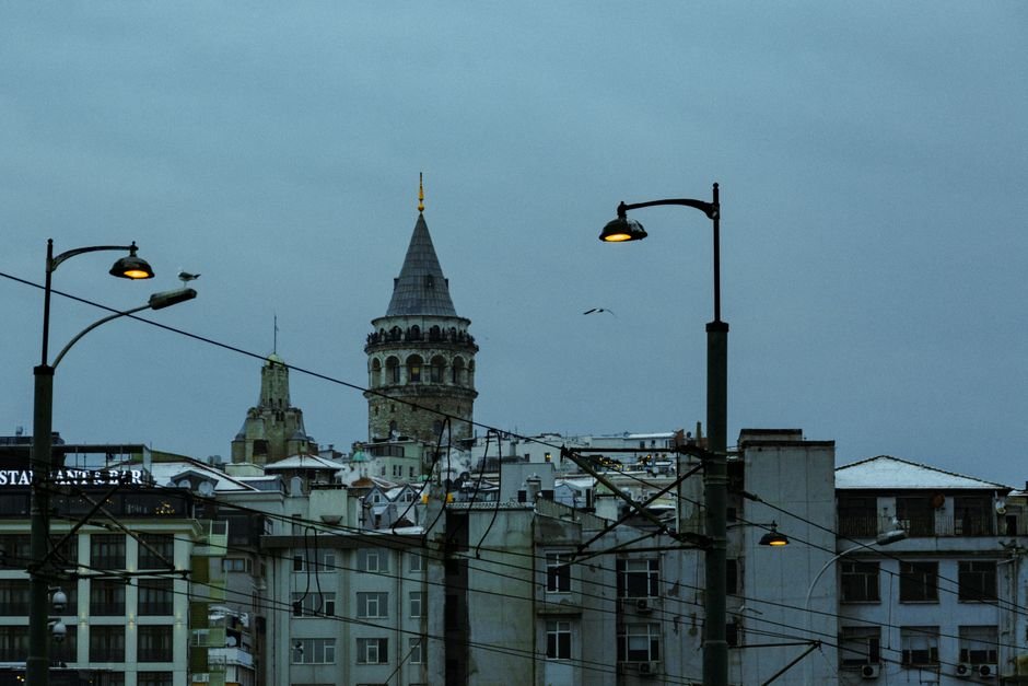 Emily Watson Joins JFK Assassination-Inspired Short Film ‘The Drive’ as Executive Producer Night view of Galata Tower amidst Istanbul's cityscape with streetlights illuminating the urban environment.