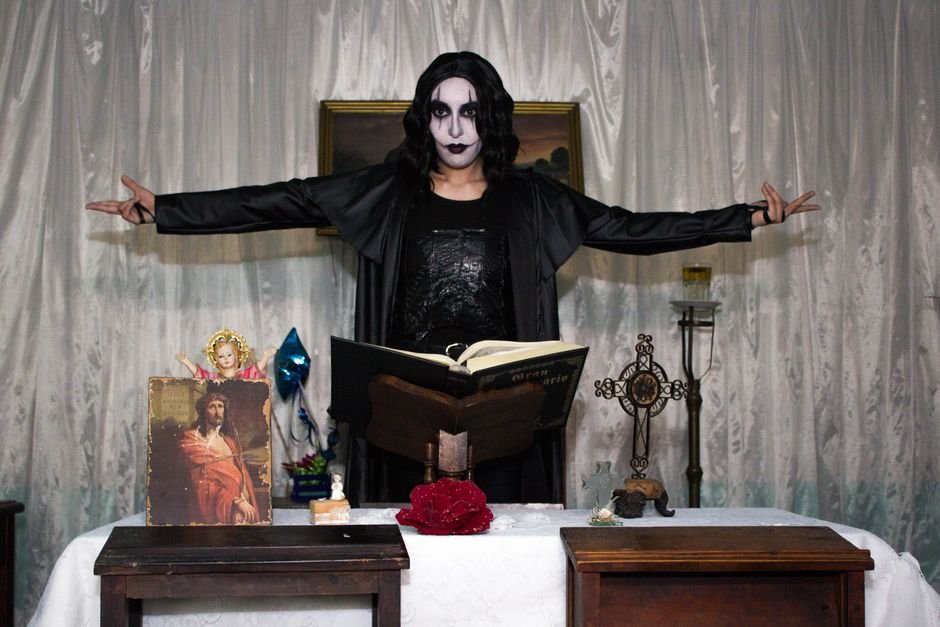 Jack Osbourne and Daughter Pearl Immerse Themselves in Ozzy Osbourne’s Horror Tribute Person in gothic costume performing a dramatic scene indoors with religious symbols.