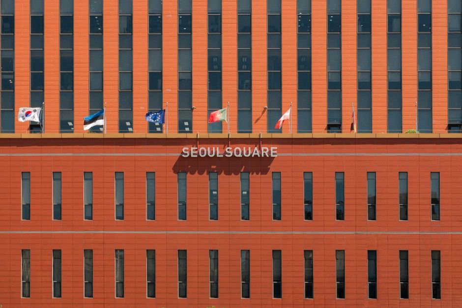 Netflix Research Reveals Strong Global Interest in Visiting South Korea, Fueled by Local Storytelling Red facade of Seoul Square with multiple international flags displayed.