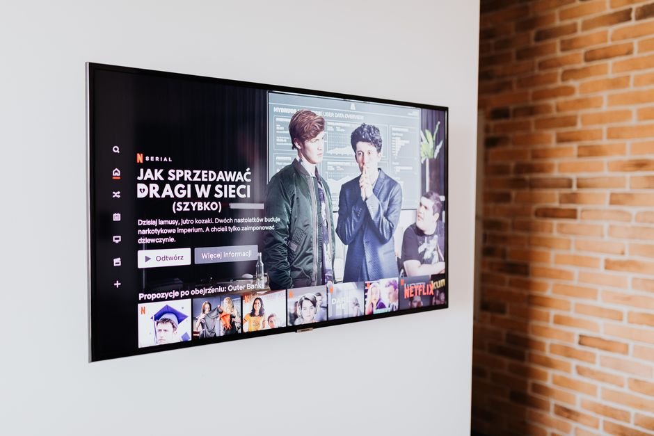 Ted Sarandos Celebrates Netflix’s Decade in South Korea Amid U.S. Scrutiny Smart TV displaying streaming content in modern living room setting with exposed brick wall.