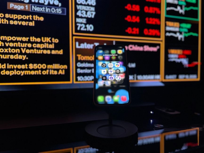 European Financial Firms Leverage Open Models for Proprietary Intelligence Smartphone displaying AI apps in front of a financial data screen in London.