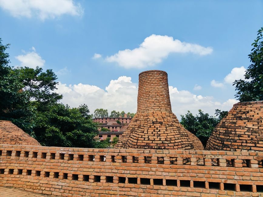 Three Minors Rescued From Brick Kilns in Andhra Pradesh’s Konaseema District Traditional brick kilns under a clear blue sky surrounded by lush greenery.