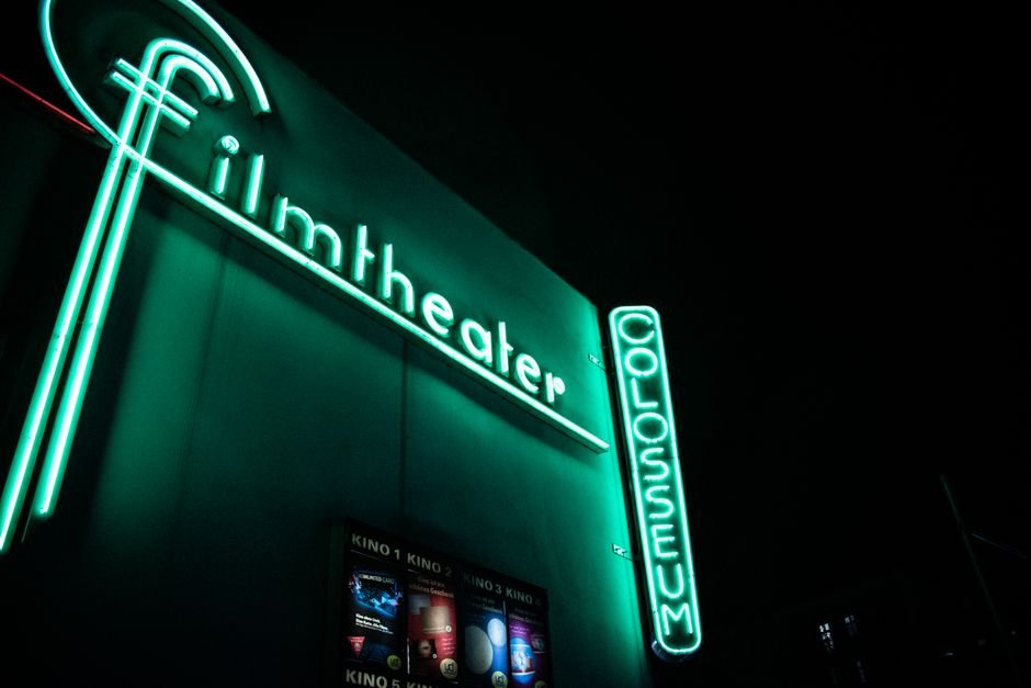 Marcus Theatres CEO Urges Studios to Extend Theatrical Window, Citing Impact on Home Release Promotions Vibrant neon film theater sign glowing at nighttime.