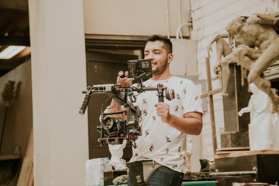James Watkins Confirms Aaron Paul’s Brief Role in DC Studios’ ‘Clayface’ Videographer working with a professional stabilizing rig indoors, capturing behind-the-scenes moments.